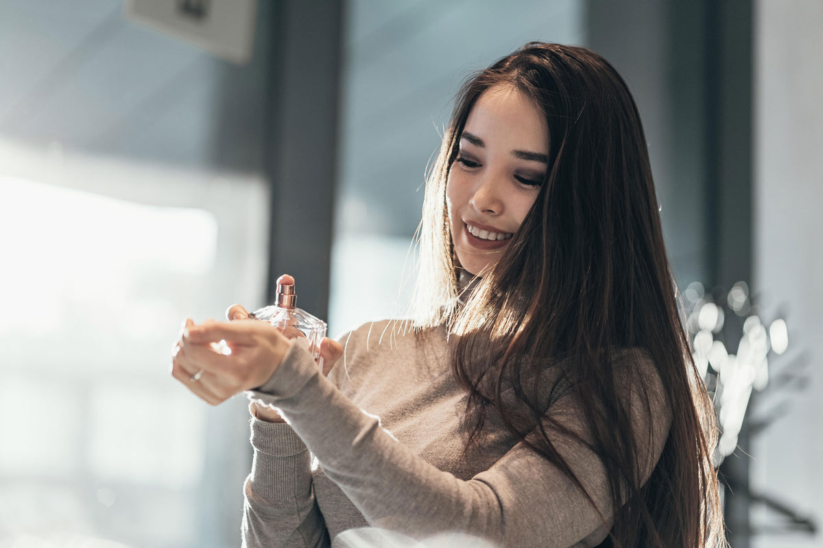 Woman spraying perfume on wrist